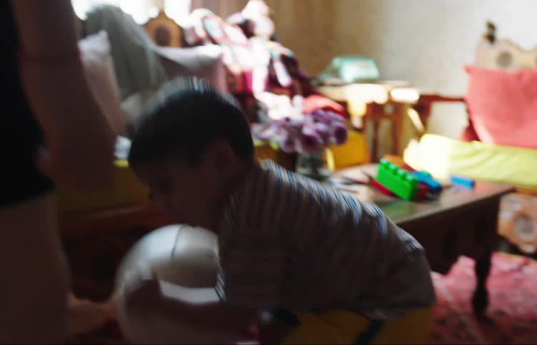Two children are playing with a soccer ball indoors