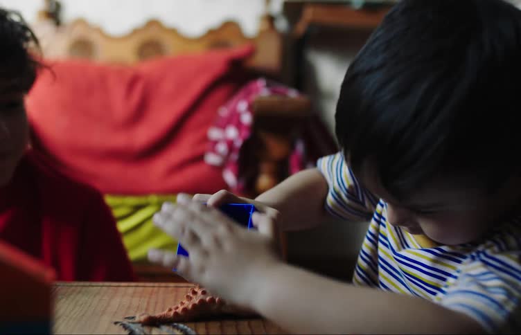 Two children play with toys together at home