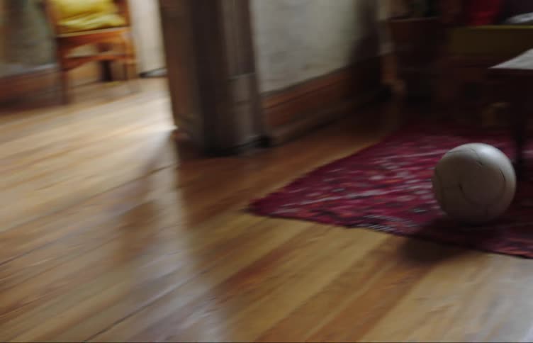 Boy plays with soccer ball in living room