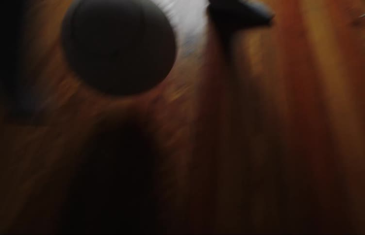 A boy kicks a soccer ball around a living room