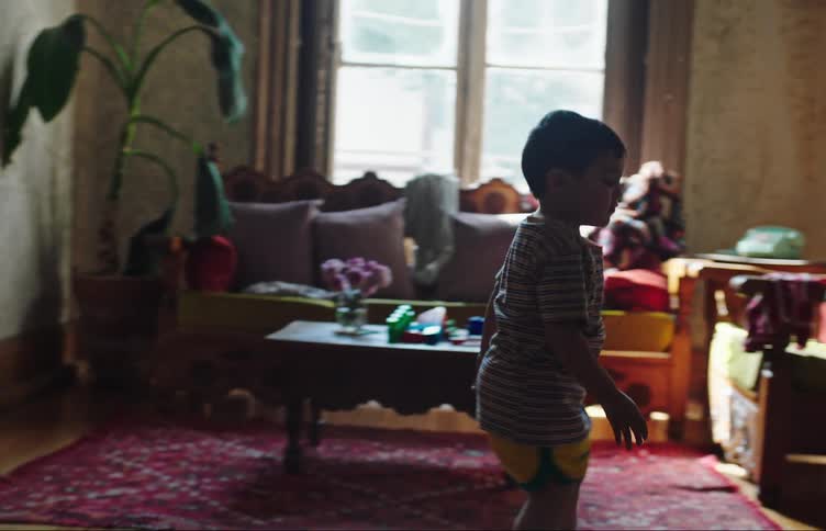 Younger brother captures soccer ball from older brother while they play together at home