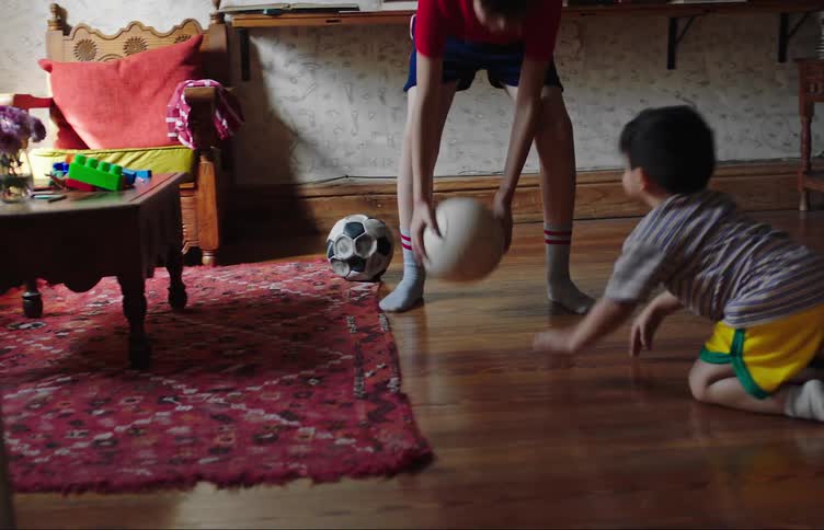 Two kids play with a soccer ball