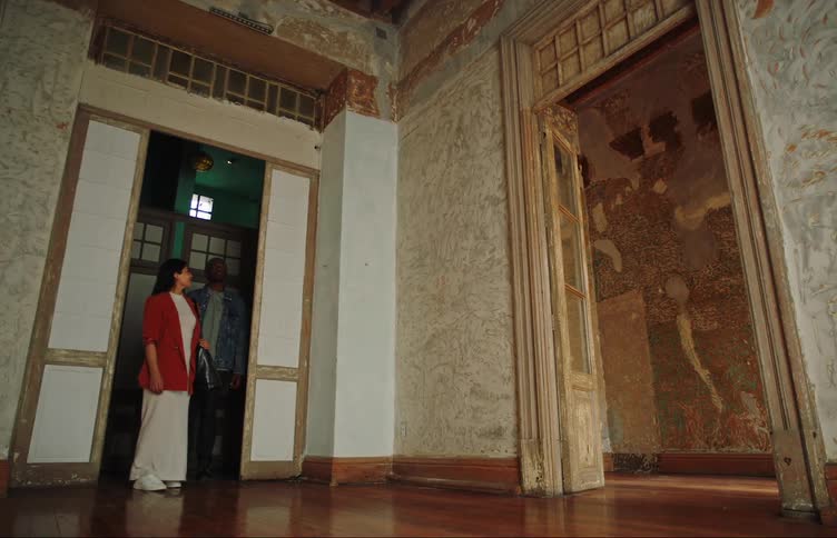 A couple enters a room and looks around