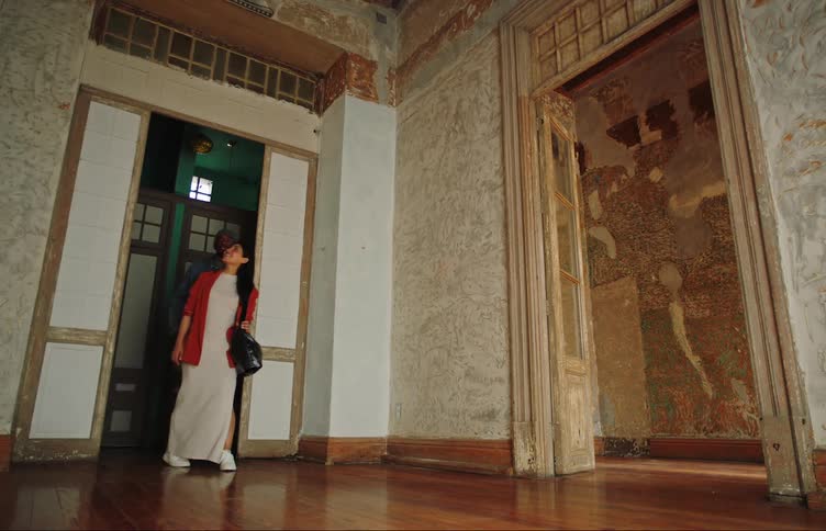 Couple entering through the door of a house without furniture and with architectural walls