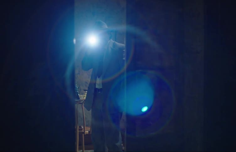 A man is searching around with a flashlight