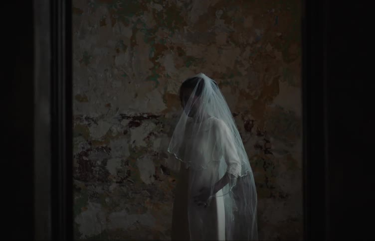 Woman smiles while trying on a wedding dress at home