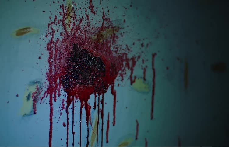 Red paint marks on a wall being illuminated by a flashlight