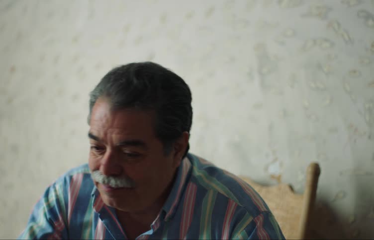 Close up of a latino man sitting on a room talking