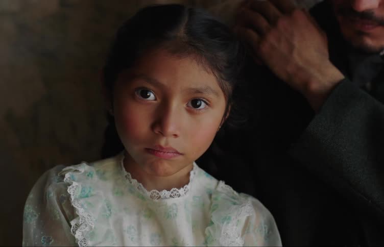 Portrait of a young little girl posing for a photo next to her father and mother