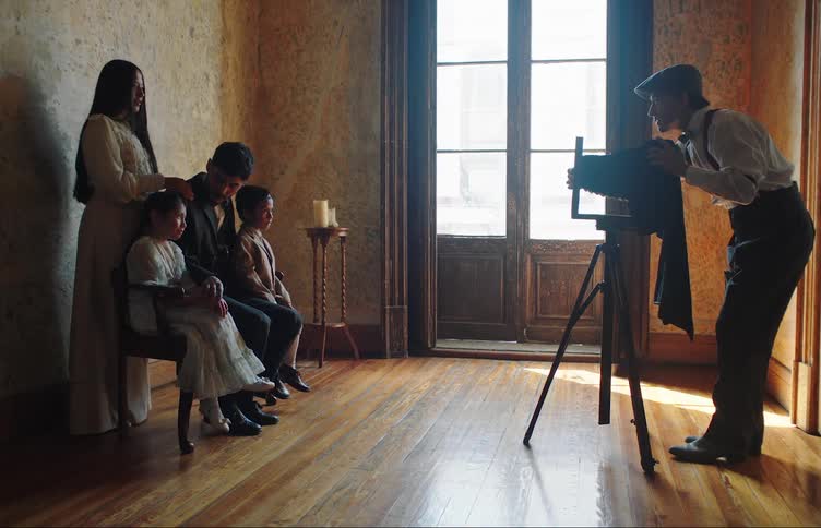 A photographer takes a picture of a family using an old camera