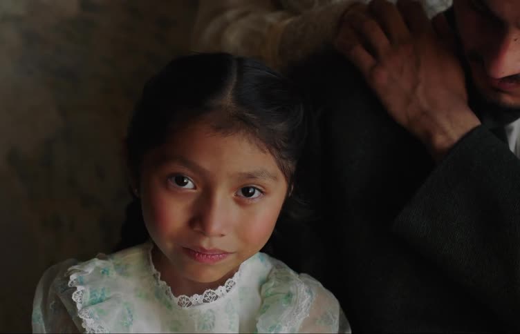 Latino child wearing a dress looking at the camera