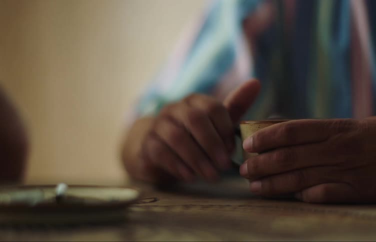 A person holds his mug as they move their hands around