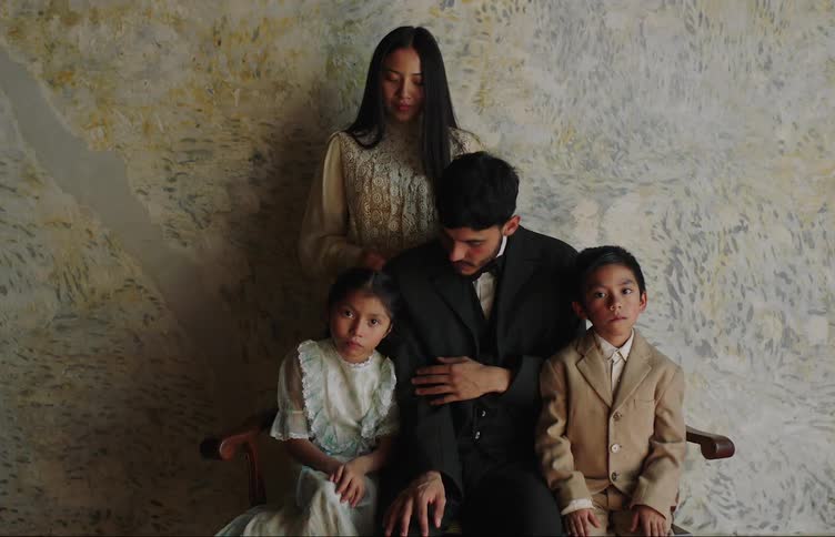 A family sit down and pose for a photograph