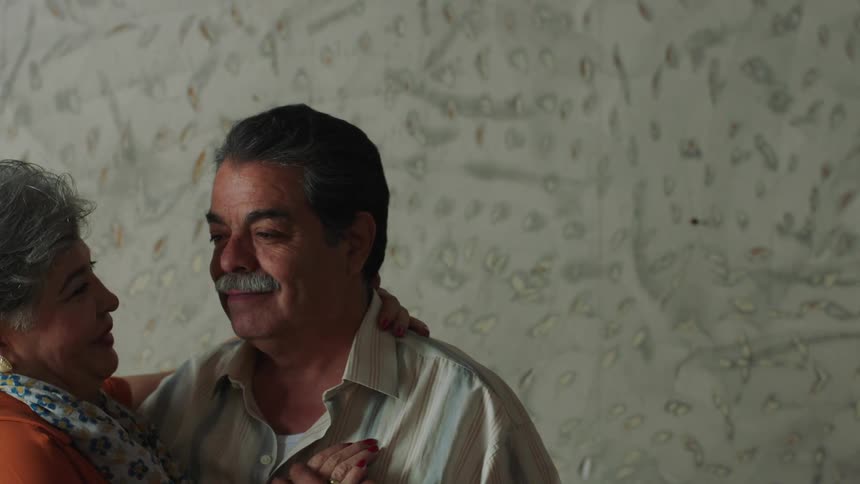 Couple gaze lovingly at each other as they slow dance