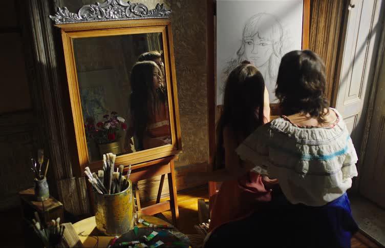 Mother holding her little daughter who draws on a whiteboard happily