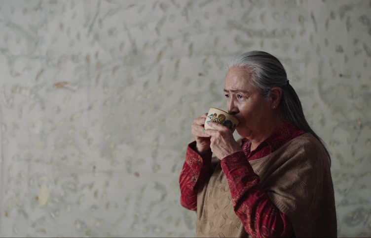A woman savors a drink from a cup