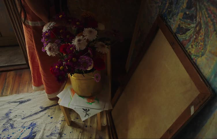A girl in a red dress arranges flowers on a vase