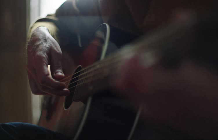Closeup of a person playing the guitar