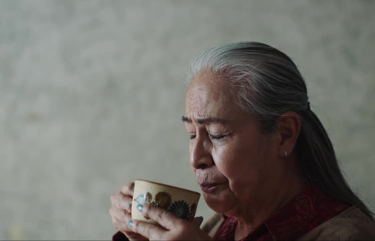 Portrait of an elderly lady drinking a mug