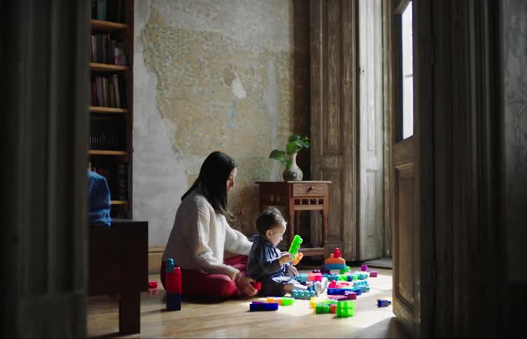 A mother and her son play with building blocks