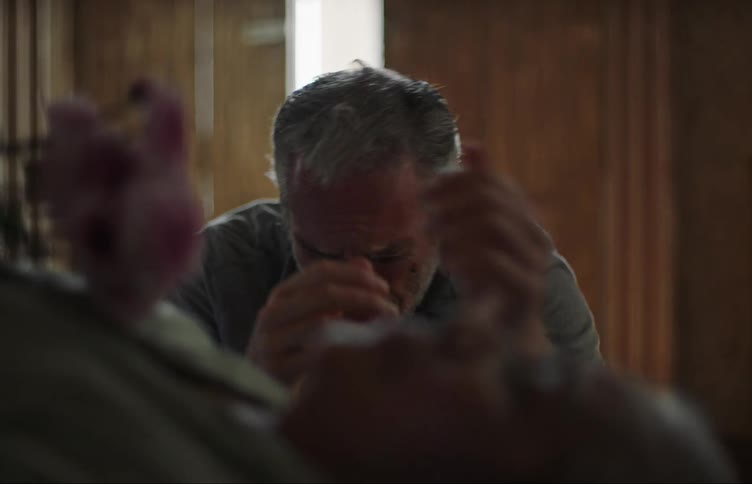 Man crying while facing a dead woman