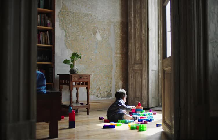 Toddler playing with plastic toys on the floor of a room