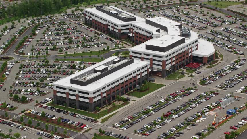 Aerial panorama of a blocky complex with a parking lot around it