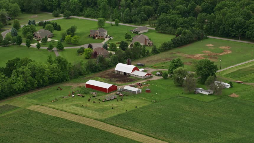 A farm sits near a neighborhood in a rural area