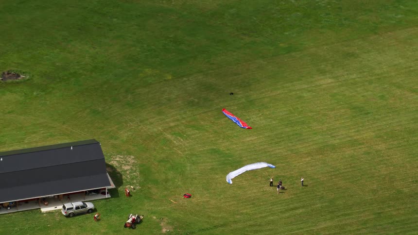 People are paragliding from the field