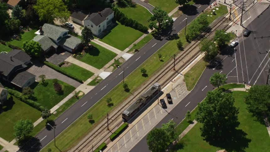 A train slows down at a traffic crossing in the suburbs