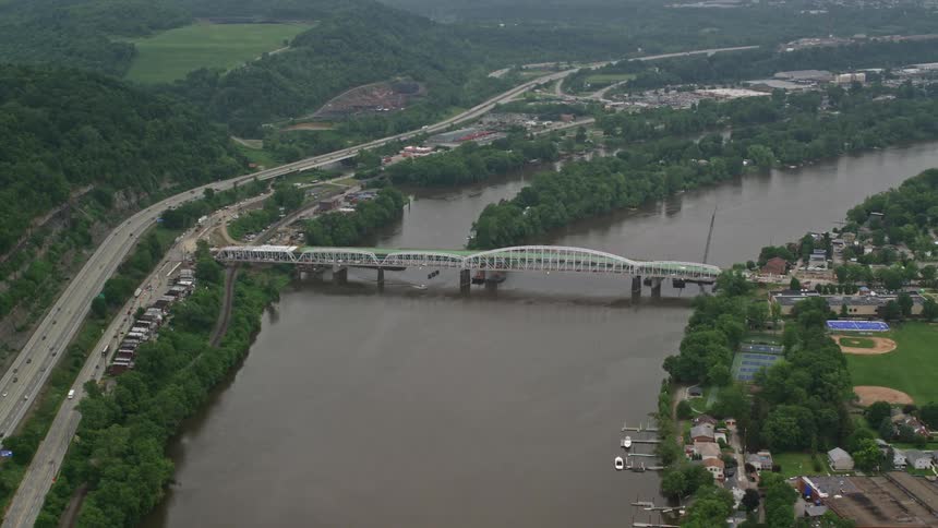 Aerial panorama of a bridge under the river connecting residential cities and factories