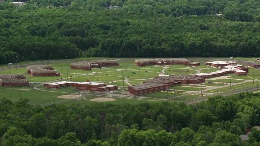 Aerial panorama of a remote complex in a location with surrounding forest and fenced area