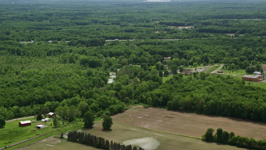 Aerial view of a green landscape with fields and sparse buildings