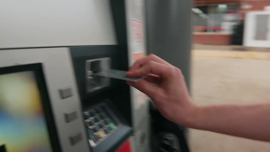 A male inserts a credit card into a gas pump card reader