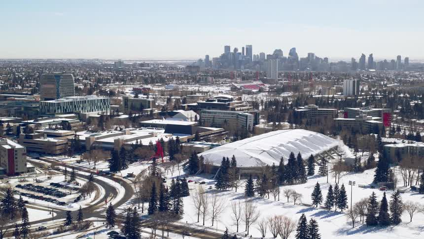 University campus and sports arena with cityscape visible in the background