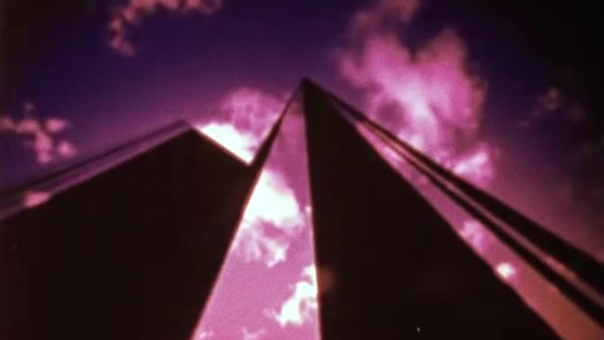 Two buildings at an upward angle filmed at dusk
