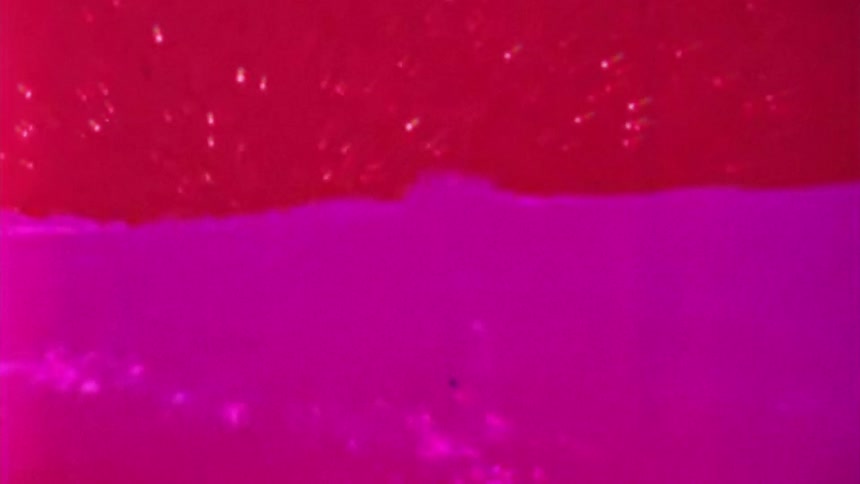 A pink and red substance slowly mixing