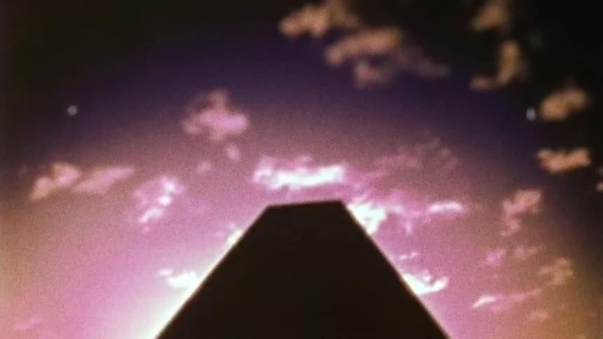 Upwards angle of a tall building while the sun is setting
