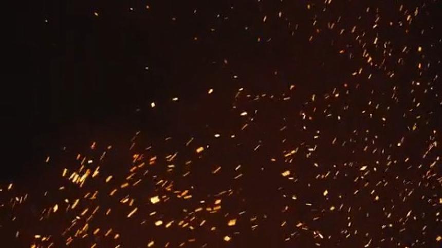 Slow motion footage of fire embers blowing in the wind