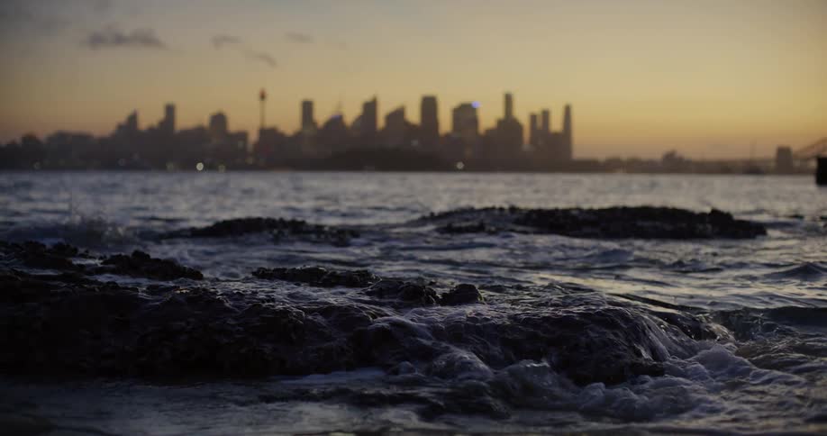 The waves crash against the rocks of the shore