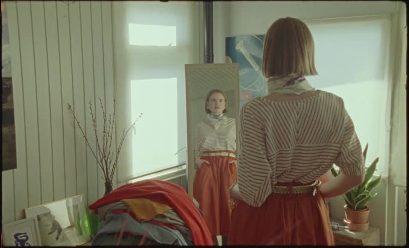 Woman standing in front of a mirror and looking at her reflection