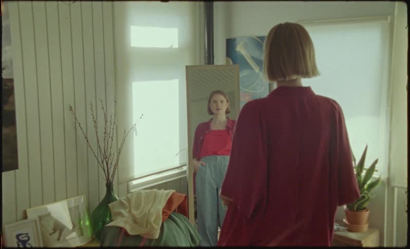 A white woman stares into a mirror