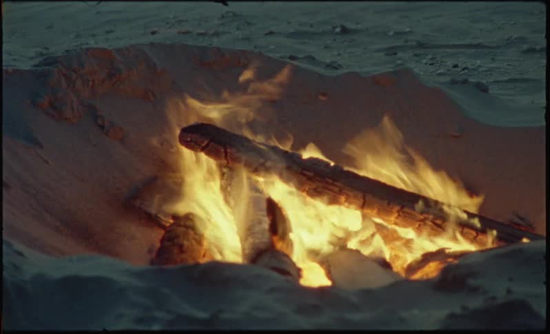 Small bonfire on the beach sand at dusk