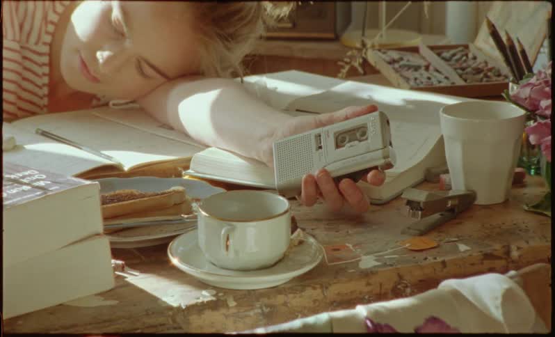 Woman talking on a tape recorder at the dining room table