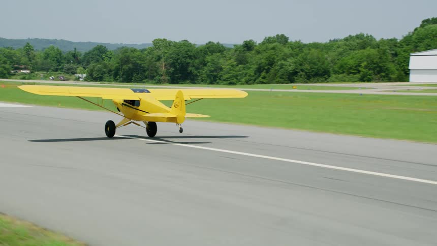 A plane takes off from a rural airfield