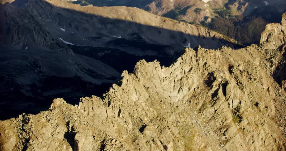 A few spots of snow lie on mountains terrain and shadowed valleys