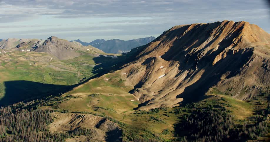 Aerial panorama of mountain peaks on a blue sky day with clouds