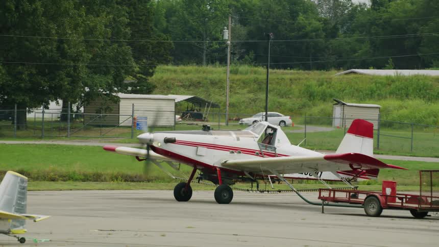 Small singleengine plane parked with the front propeller turned on