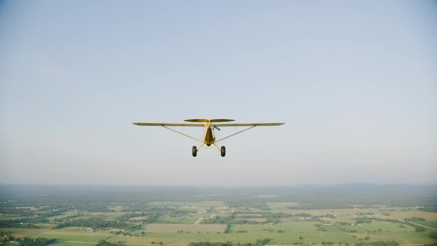 An airplane flies over fields