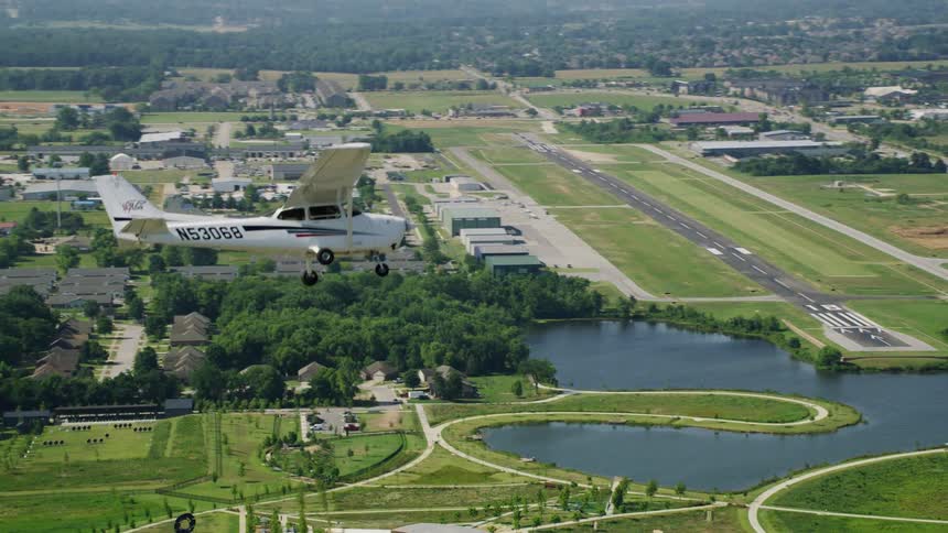 Single engine plane flying near the airport runway